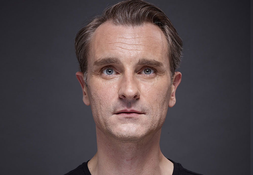 Man face with blue eyes on grey background | Fillmed