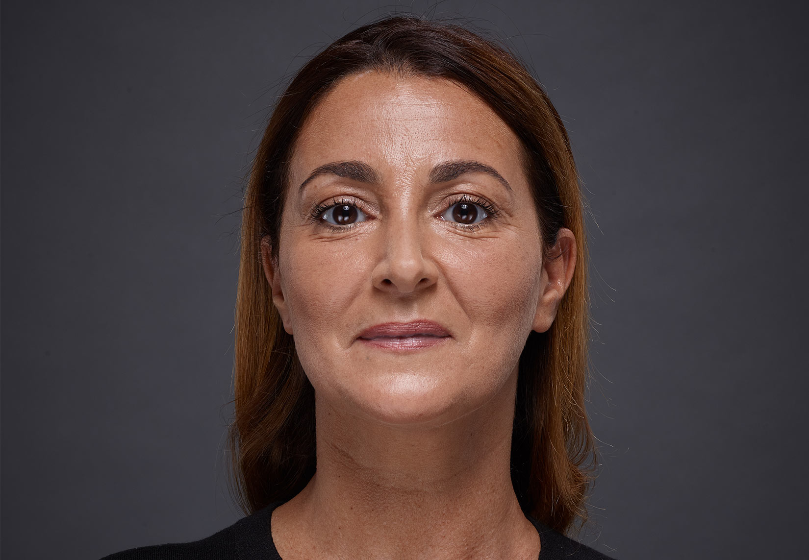 Woman face with brown eyes and brown hairs on grey background | Fillmed